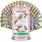 Fresh Cut Peony Cash Money Candle with two lit wicks and a fan of cash