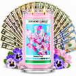 Sweet Pea Cash Money Candle with two lit wicks and a fan of cash